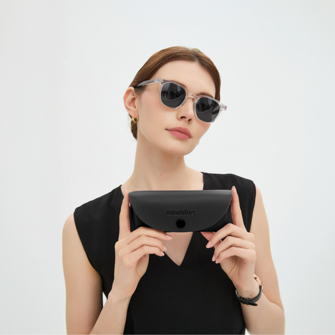 Modelo sosteniendo el estuche protector de Auguste – gafas de sol con montura Crystal