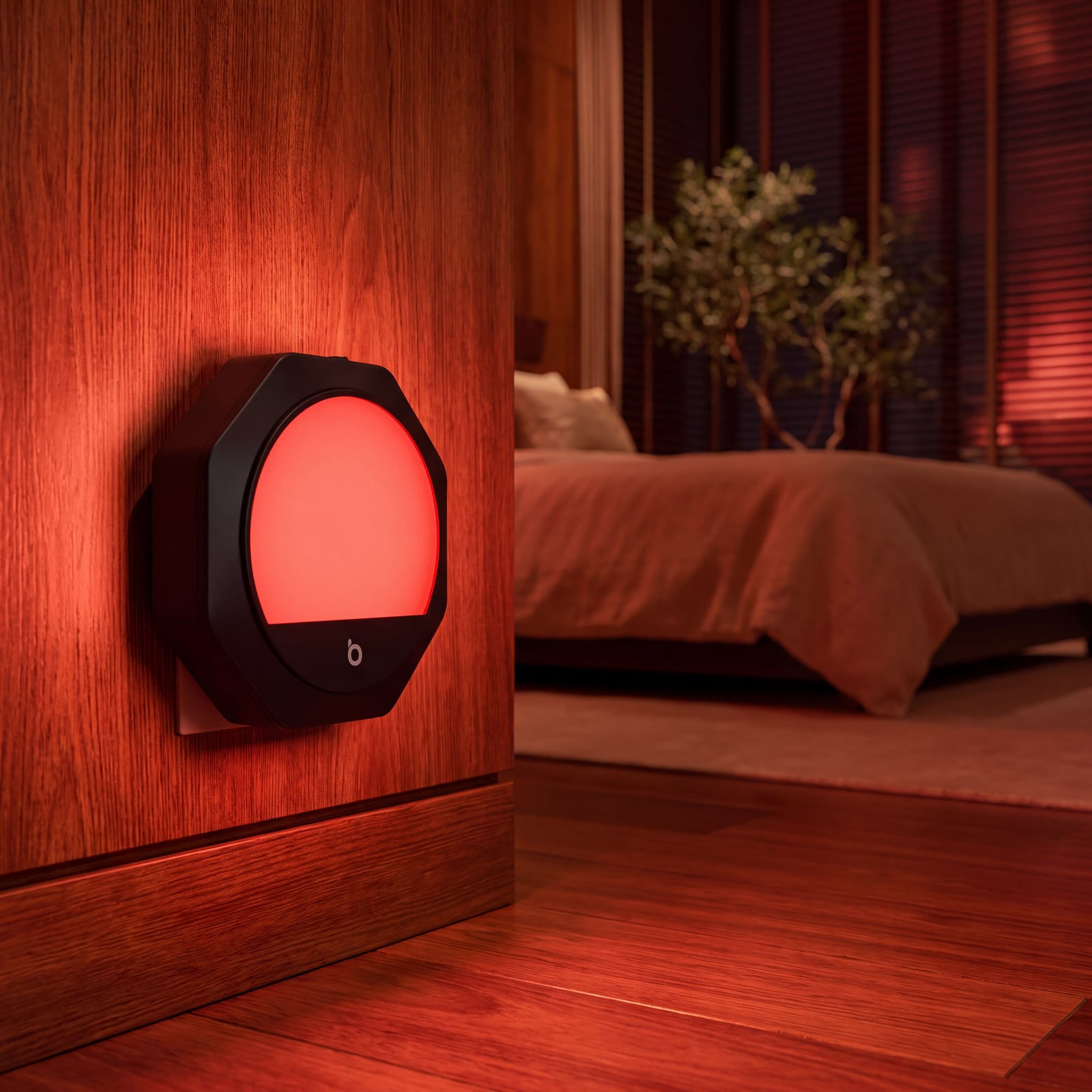 Una luz nocturna roja de enchufe brillando en la pared de un dormitorio